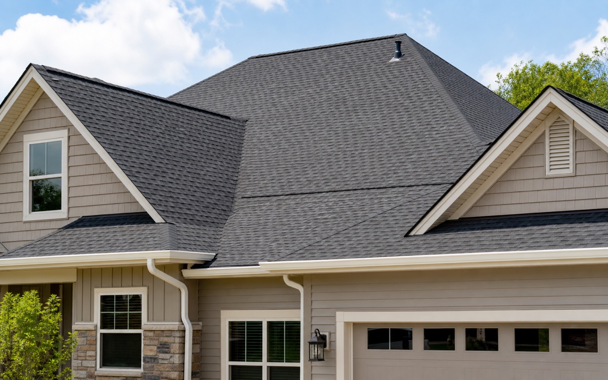 Residential roofline with architectural shingles and clean gutters.